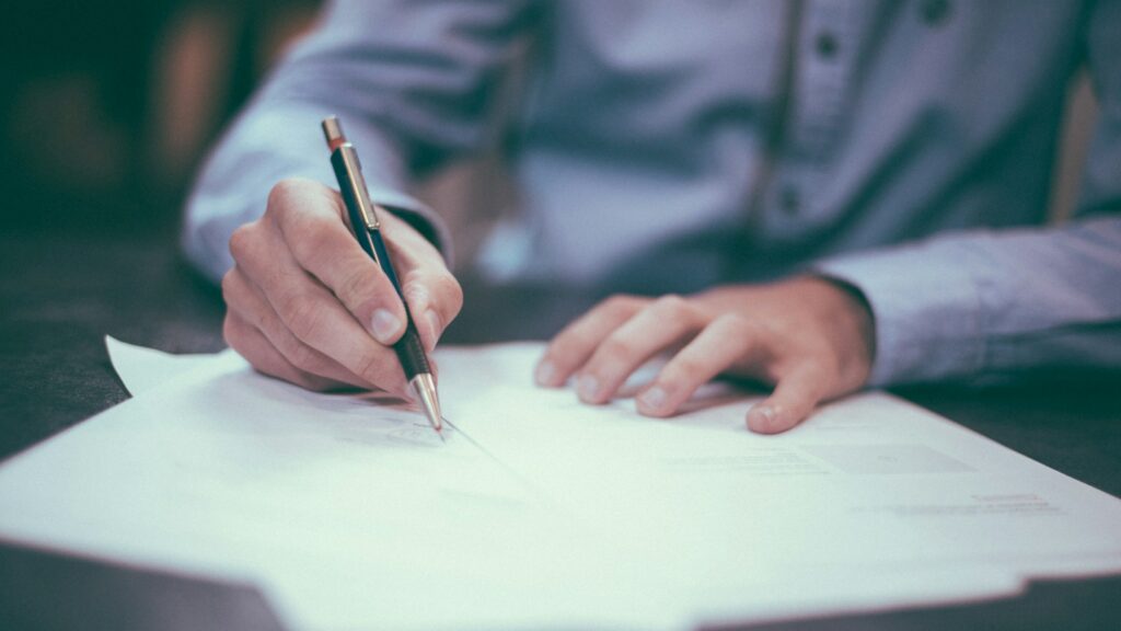 Persona firmando un documento con un bolígrafo
