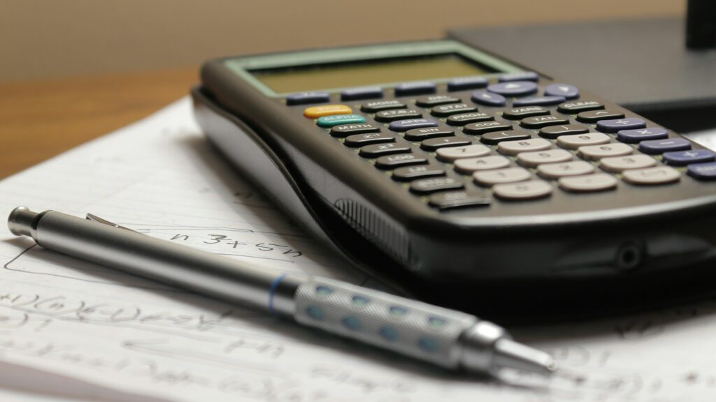 Calculadora y bolígrafo sobre unas hojas de cuentas